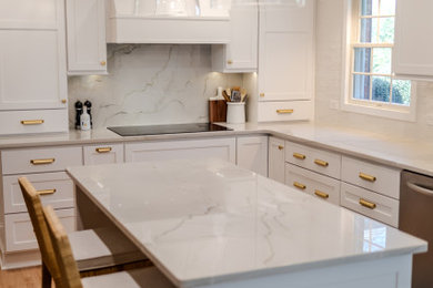 Klassisk inredning av ett mellanstort vit vitt kök, med en undermonterad diskho, skåp i shakerstil, vita skåp, bänkskiva i kvartsit, vitt stänkskydd, stänkskydd i sten, rostfria vitvaror, ljust trägolv, en köksö och brunt golv