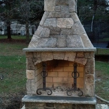 Outdoor Fireplace with Natural Stone Features in NY Backyard