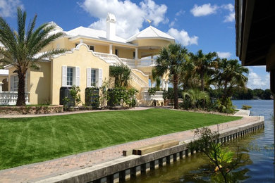 Photo of a mid-sized traditional full sun backyard brick landscaping in Miami.