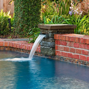 Mittelgroßer Klassischer Schwimmteich hinter dem Haus in individueller Form mit Wasserspiel und Pflasterklinker in Houston