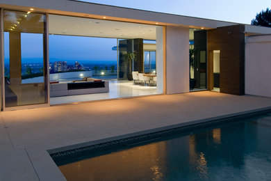 Mid-sized trendy concrete paver and rectangular lap pool photo in Los Angeles