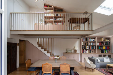 Idées déco pour une grande salle de séjour mansardée ou avec mezzanine classique avec une bibliothèque ou un coin lecture, un mur rose, parquet clair, aucune cheminée, aucun téléviseur, un sol beige et poutres apparentes.