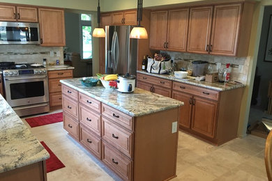 Eat-in kitchen - ceramic tile eat-in kitchen idea in Detroit with an undermount sink, raised-panel cabinets, medium tone wood cabinets, ceramic backsplash, stainless steel appliances, an island and granite countertops