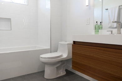 Example of a mid-sized minimalist kids' white tile and ceramic tile ceramic tile and gray floor bathroom design in San Francisco with flat-panel cabinets, medium tone wood cabinets, a one-piece toilet and white walls