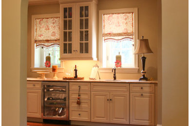 Inspiration for a large traditional single-wall wet bar in Philadelphia with raised-panel cabinets, white cabinets, granite benchtops and medium hardwood floors.