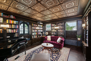 Inspiration for a mid-sized dark wood floor, brown floor and wallpaper home office library remodel in Cleveland with blue walls