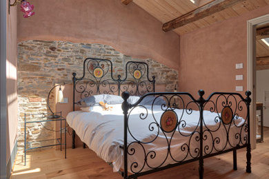 Foto di una camera da letto rustica con parquet chiaro, soffitto in legno e pareti in legno