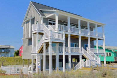 Huge beach style gray three-story vinyl exterior home photo in Other