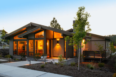 Design ideas for a midcentury one-storey exterior in Other with mixed siding and a gable roof.