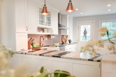 Inspiration for a large cottage l-shaped light wood floor and beige floor eat-in kitchen remodel in Other with a farmhouse sink, recessed-panel cabinets, white cabinets, granite countertops, pink backsplash, ceramic backsplash, stainless steel appliances, a peninsula and multicolored countertops