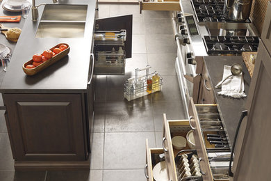 Eat-in kitchen - u-shaped brown floor eat-in kitchen idea in Other with dark wood cabinets, stainless steel appliances, an island and brown countertops