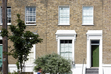 Photo of a mid-sized contemporary three-storey exterior in London with a flat roof.