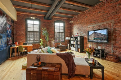 Inspiration for a large industrial open concept living room in Other with light hardwood floors and a wall-mounted tv.
