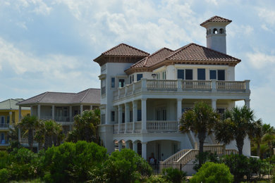 Beach style three-story stucco exterior home photo in Orlando with a tile roof