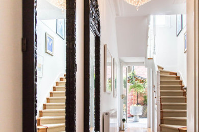 Photo of a mid-sized eclectic hallway in Melbourne with white walls and light hardwood floors.