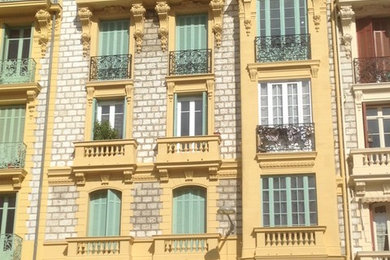 Idée de décoration pour une façade de maison jaune à deux étages et plus.