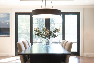 Example of a medium tone wood floor, brown floor and exposed beam dining room design in New York with beige walls