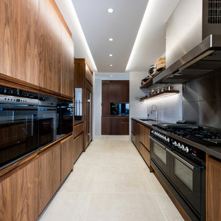 Inspiration for an expansive tropical galley kitchen pantry in Gold Coast - Tweed with an undermount sink, medium wood cabinets, granite benchtops, multi-coloured splashback and mirror splashback.