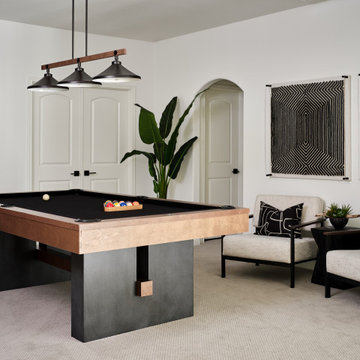 Belterra Project- Furnishings, Lighting Fixtures Interior Design</p><p>This sophisticated game room provides hours of play for a young and active family. The black, white and beige color scheme adds a masculine touch. Wood and iron accents are repeated throughout the room in the armchairs, pool table, pool table light fixture and in the custom built in bar counter. This pool table also accommodates a ping pong table top, as well, which is a great option when space doesn’t permit a separate pool table and ping pong table. Since this game room loft area overlooks the home’s foyer and formal living room, the modern color scheme unites the spaces and provides continuity of design.</p><p> A custom white oak bar counter and iron barstools finish the space and create a comfortable hangout spot for watching a friendly game of pool.</p><p><img decoding=