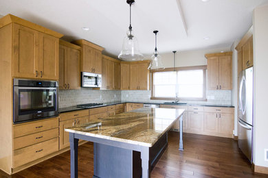 Example of a large classic l-shaped dark wood floor eat-in kitchen design in Minneapolis with an undermount sink, shaker cabinets, light wood cabinets, granite countertops, subway tile backsplash, stainless steel appliances and an island