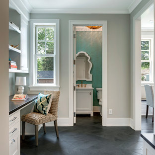 Photo of a small transitional study room in Minneapolis with white walls, slate floors, a built-in desk and grey floor.