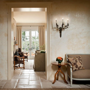 Foto di un corridoio mediterraneo di medie dimensioni con pareti beige, pavimento in travertino, una porta singola e una porta bianca