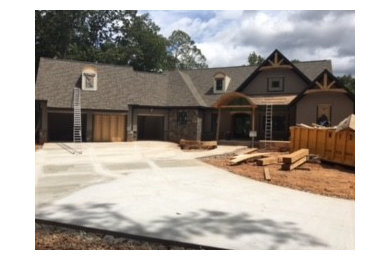 Inspiration for a large timeless gray two-story stone house exterior remodel in Atlanta with a clipped gable roof and a shingle roof