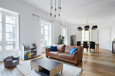 Cette image montre un salon blanc et bois minimaliste ouvert avec un mur blanc, parquet clair, une cheminée standard et éclairage.