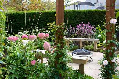 Photo of a contemporary backyard partial sun garden in Edinburgh with natural stone pavers.
