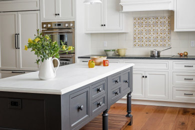 Large farmhouse l-shaped dark wood floor and brown floor eat-in kitchen photo in New York with a single-bowl sink, flat-panel cabinets, gray cabinets, marble countertops, yellow backsplash, ceramic backsplash, white appliances, an island and white countertops