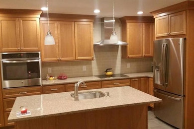Mid-sized elegant kitchen photo in New York with medium tone wood cabinets and an island