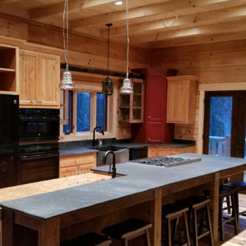 Contemporary soapstone countertops with rustic reclaimed barnwood base in a log