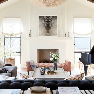 Foto de salón con rincón musical abierto, mediterráneo, de tamaño medio, con paredes blancas, suelo de madera en tonos medios, chimenea tradicional, marco de chimenea de yeso y suelo blanco