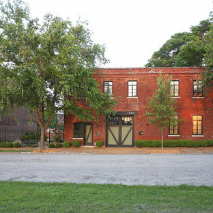 Foto på ett industriellt lägenhet, med två våningar, tegel och platt tak