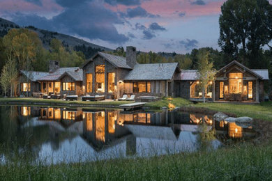 Large mountain style gray two-story mixed siding house exterior photo in Other with a hip roof and a shingle roof