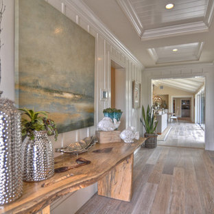 Idéer för att renovera en maritim hall, med vita väggar och mellanmörkt trägolv