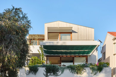 Mid-sized contemporary three-storey house exterior in Sydney with concrete fiberboard siding and a gable roof.