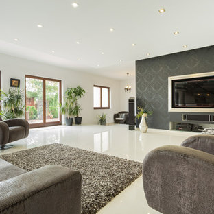Photo of an expansive modern enclosed home cinema in Los Angeles with white walls, concrete flooring, a built-in media unit and white floors.