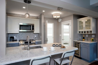 Small transitional galley porcelain tile eat-in kitchen photo in Boston with an undermount sink, shaker cabinets, blue cabinets, quartz countertops, multicolored backsplash, mosaic tile backsplash, stainless steel appliances and a peninsula