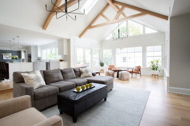 Family room - large traditional open concept light wood floor, beige floor, vaulted ceiling and wall paneling family room idea in Columbus with beige walls, a standard fireplace, a brick fireplace and a media wall