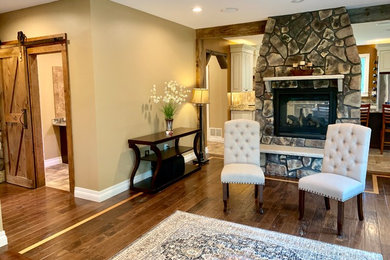 Example of a mountain style open concept dark wood floor and brown floor living room design in New York with beige walls, a two-sided fireplace and a stone fireplace