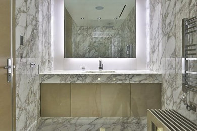 Example of a large trendy master white tile and stone slab marble floor doorless shower design in New Orleans with an undermount sink, flat-panel cabinets, brown cabinets, marble countertops and white walls