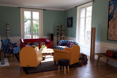 Exemple d'un grand salon moderne ouvert avec un mur bleu, parquet clair, une cheminée standard et boiseries.