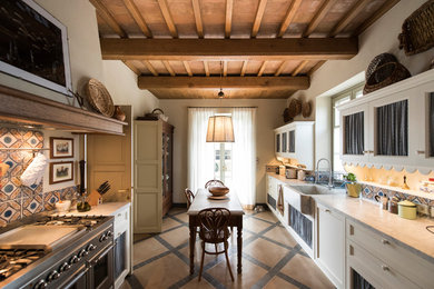 Ispirazione per una piccola cucina country con lavello stile country, ante con riquadro incassato, ante bianche, paraspruzzi multicolore, elettrodomestici in acciaio inossidabile, top in marmo, paraspruzzi con piastrelle in ceramica, pavimento in terracotta, nessuna isola, pavimento multicolore, travi a vista e top beige