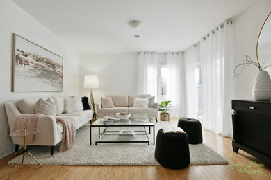 Example of a mid-sized trendy open concept light wood floor and brown floor living room design in Montreal with white walls and a media wall
