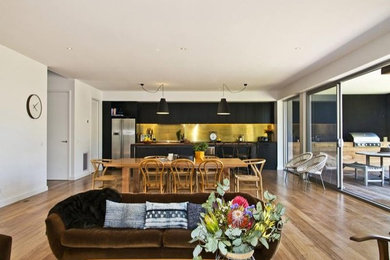 Photo of a large industrial single-wall open plan kitchen in Melbourne with tile benchtops, metallic splashback and with island.