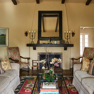 Ejemplo de salón para visitas cerrado, mediterráneo, grande, sin televisor, con paredes beige, suelo de madera oscura, chimenea tradicional, marco de chimenea de baldosas y/o azulejos y suelo marrón