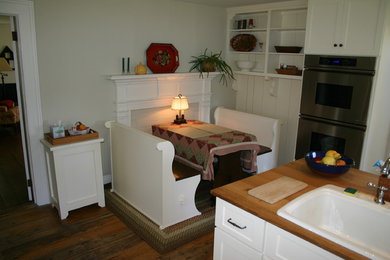 Diseño de cocina comedor de estilo de casa de campo sin isla con fregadero encastrado, armarios con paneles empotrados, puertas de armario blancas, encimera de madera y suelo de madera oscura