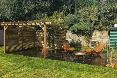 Ejemplo de jardín actual pequeño en verano en patio trasero con privacidad, exposición total al sol, adoquines de piedra natural y con madera