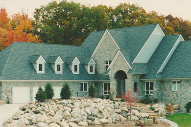 デトロイトにある高級なトラディショナルスタイルのおしゃれな家の外観 (石材サイディング) の写真